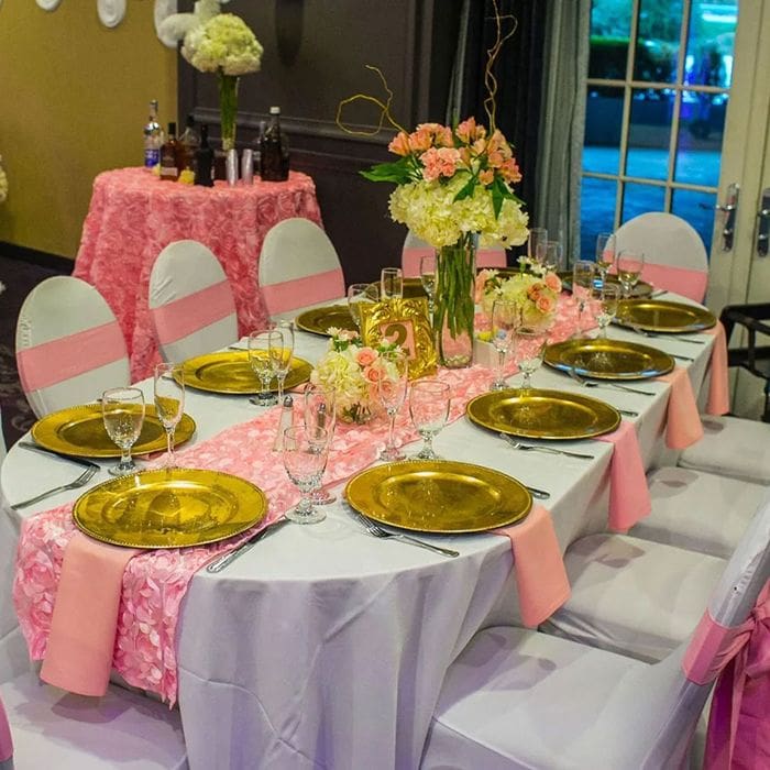 Baby shower table with pink decor, gold plates, and a floral centerpiece in Yonkers, NY